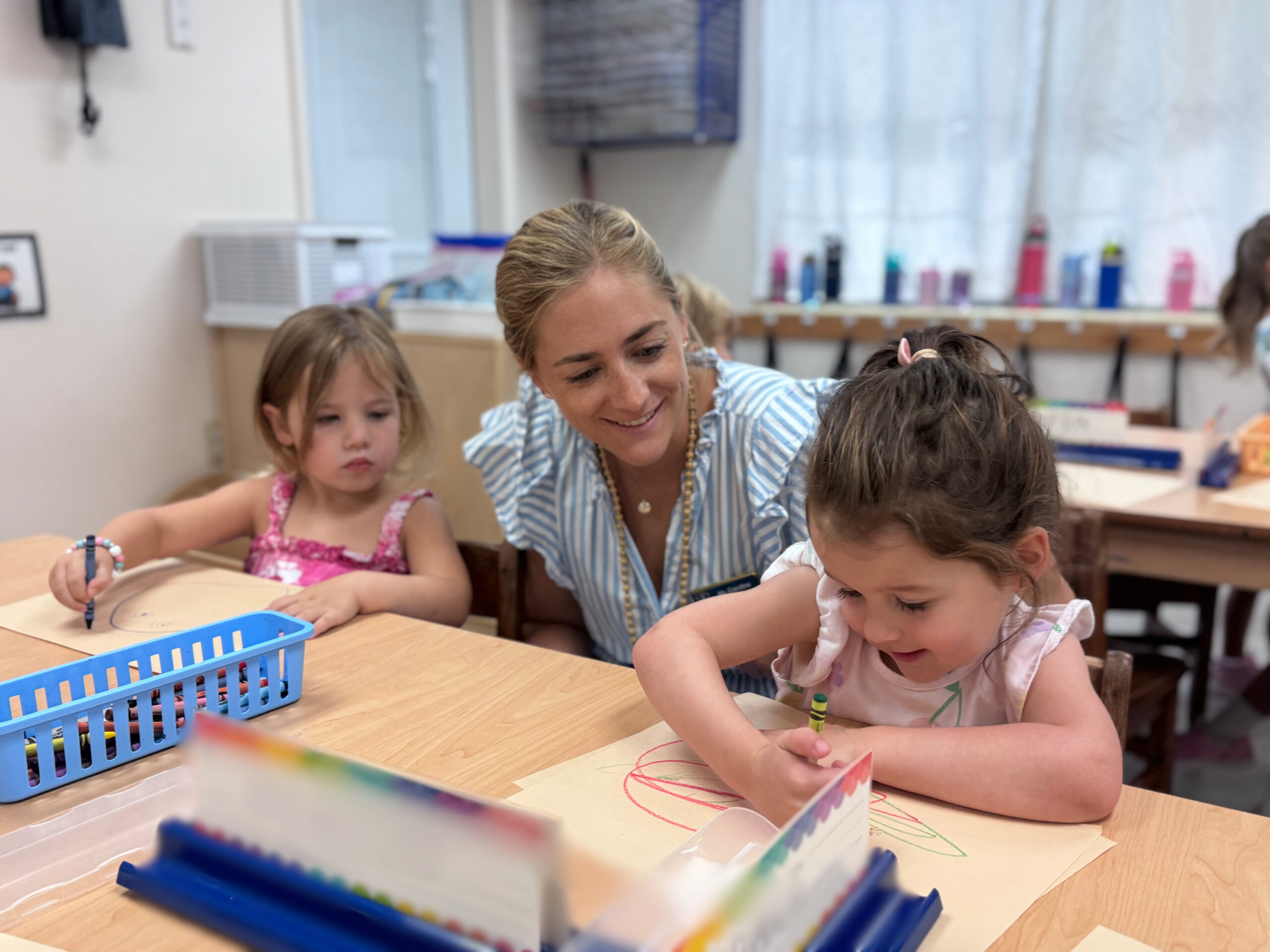Three's Teacher with students at desk